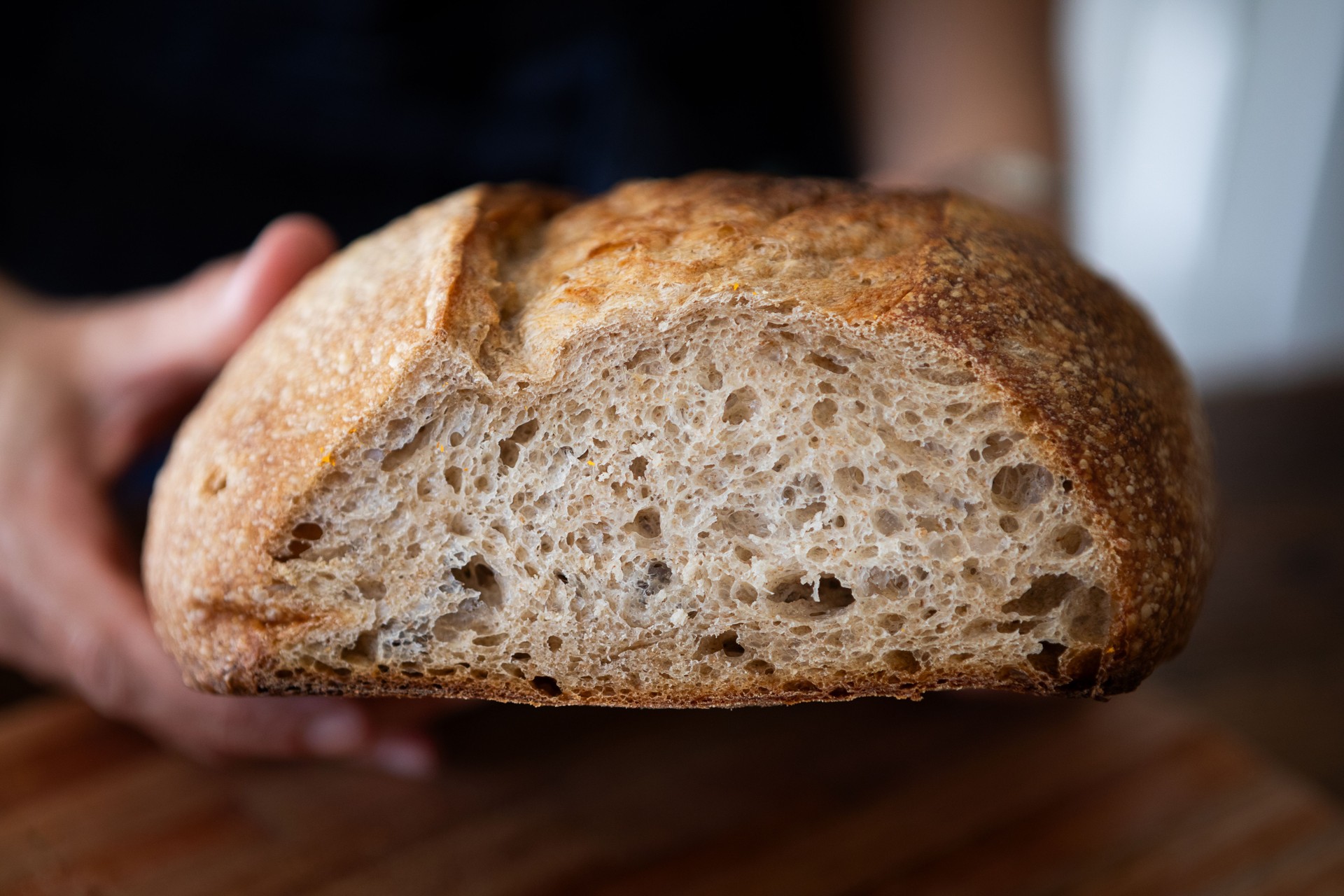 Close-up of woman's hands with sourdough fresh bread